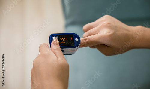 Картината върху платно woman using medical oximeter equipment to measure pulse oxygen saturation