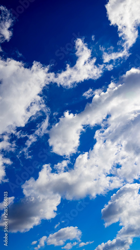 Cuadro en lienzo vertical view of dynamic clouds in a blue sky