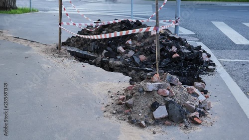 Roadwork creating hazardous conditions on sidewalk with rubble and caution tape