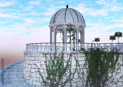Fotografie Decorative white domed gazebo with ivy covered stone walls and a spiral staircase set against a soft blue sky