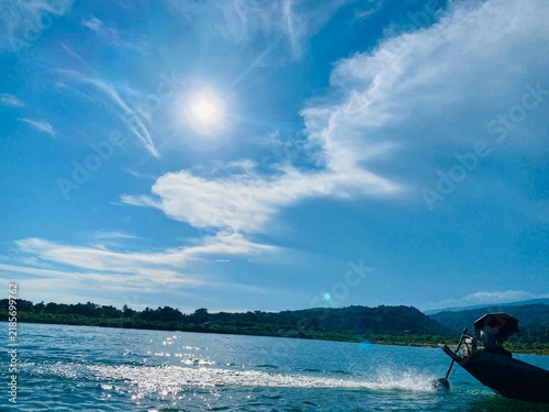 Beautiful River Landscape with Sunlight, Blue Sky, Clouds and Boat