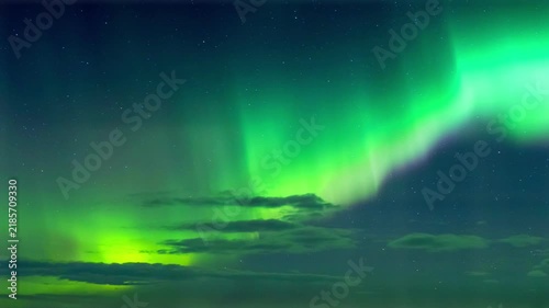 Brilliant Green Aurora Borealis Over Clouds and Starry Night Sky