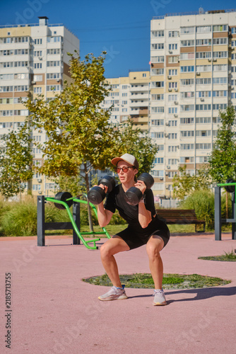 The girl is doing sports on the street playground.
