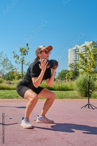 The girl is doing sports on the street playground.