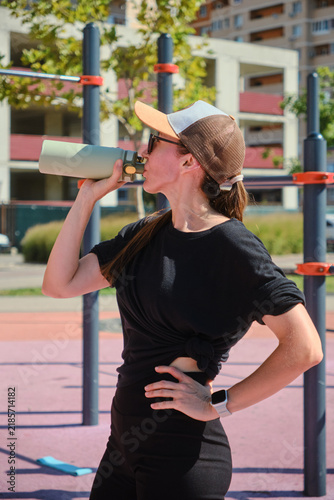The girl is doing sports on the street playground.