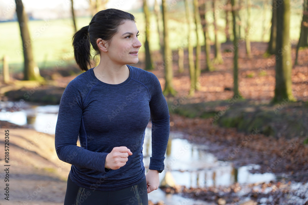 Obraz premium Young athletic woman in winter sportswear jogging, running and training outdoors on a early autumn morning 