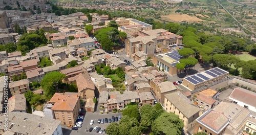 Aerial view of terracotta rooftops in the historic center of Orvieto, in the province of Terni, Umbria, Italy, with San Domenico church rising above the dense townscape. It's a sunny morning.