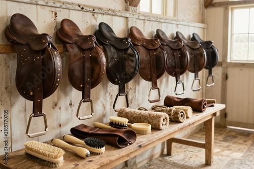 Leather saddles hanging on wall in tack room display workshop
