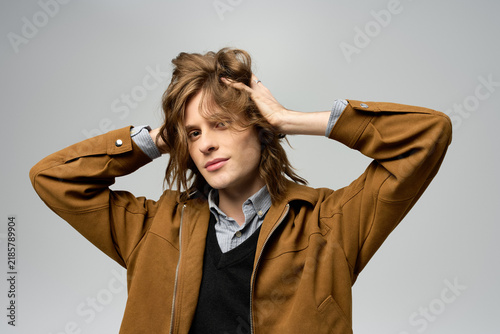 Foto Young man showcases stylish fashion with a confident pose in a minimalistic sett