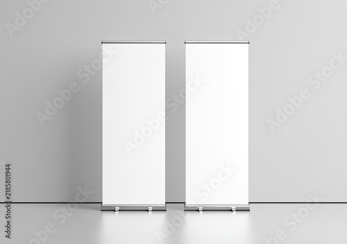 Two blank, tall display stands against a plain wall in a studio