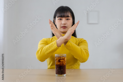 Cuadro en lienzo No soda black water concept, woman making stop gesture behind glass of sugary soft drink at home, sugar reduction, healthy choice, nutrition, wellness, diet, lifestyle