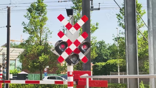 Train signals at a crossing during a sunny day in the city