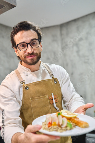 Chef presenting plated gourmet meal with confidence