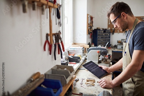 Locksmith Utilizing Digital Tablet for Key Duplication in Workshop