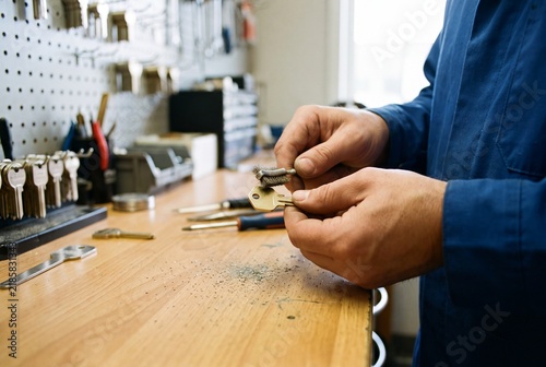 Locksmith Polishing Brass Key With Wire Brush at Industrial Workbench