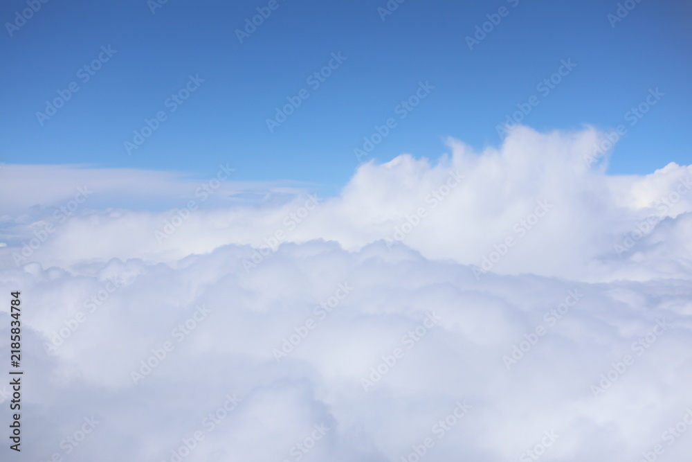 Obraz premium Aerial view of fluffy white clouds and bright blue sky background 
