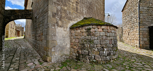 Ancient, cobbled stone streets of Castle of La Garde-Guerin, France; old heritage village in Southern France on sunny summer day, no people; ancient building, passageway in Chateau de la Garde-Guerin