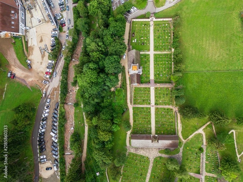 Obraz na plátne Aerial view of Ortisei cemetery area with orderly graves, chapel and surrounding trees
