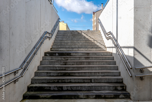 Concrete Stairway Rising Between White Walls Toward Blue Sky