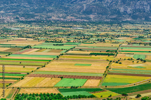 Turkey agricultural landscape with colorful fields, rural village, mountain valley, scenic countryside and dramatic cloudy blue sky