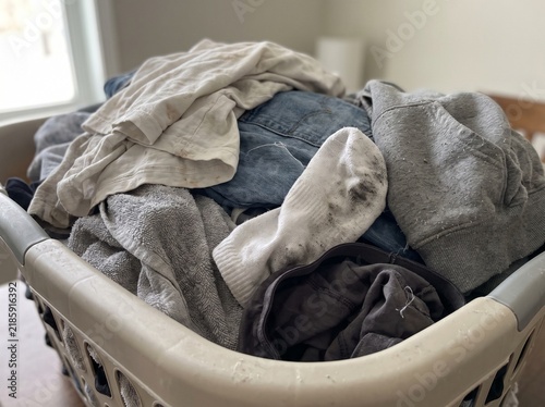 Full Laundry Basket Overflowing With Used Clothing Items Ready for Washing Routine in a Household Setting