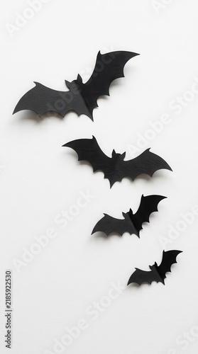 Minimalist Halloween Decoration with Black Paper Bats Flying on White Background - Creative DIY Concept for Spooky Season