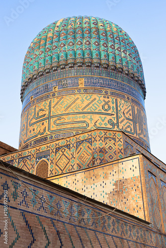 Fotografie Ribbed turquoise dome of Bibi-Khanym Mosque in Samarkand featuring intricate geometric tilework and golden brickwork
