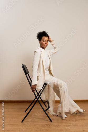 Fotografía Elegant pose of a young woman in stylish white outfit captured indoors