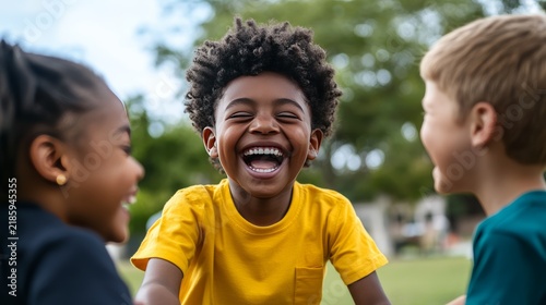 Pure Joy of Childhood: Three happy, diverse children share a moment of pure, unadulterated joy, laughing heartily outdoors in the sunshine, embodying the carefree spirit of youth.