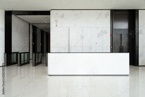 Fototapeta kuchenna Modern minimalist office building reception desk area with marble walls