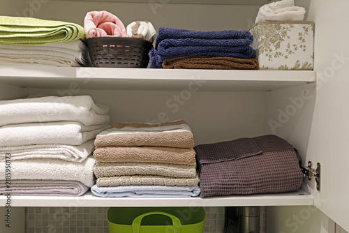 Aesthetic home storage organization with neatly folded bathroom towels.