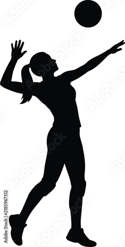 Silhouette of female volleyball player serving ball.