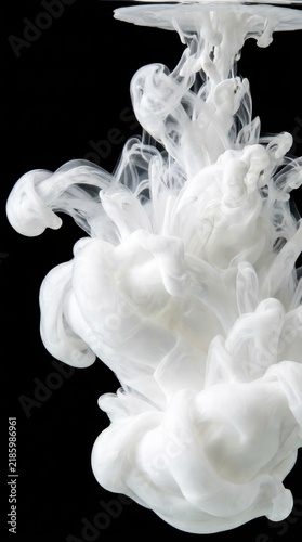 White Ink Dropping in Water on Black Background