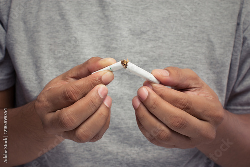 Obraz na plátne Man Breaking Cigarette in Half to Quit Smoking