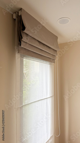 Luxury roman blinds with white sheer curtain on a condominium window