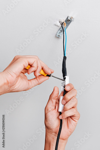 a man connects the electrical cord of a ceiling light