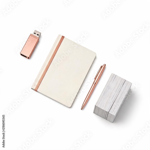 Stationery set with a white notebook a rose gold branding kit pen flash drive with stack white cards plain white background flat lay arrangement blank notebook