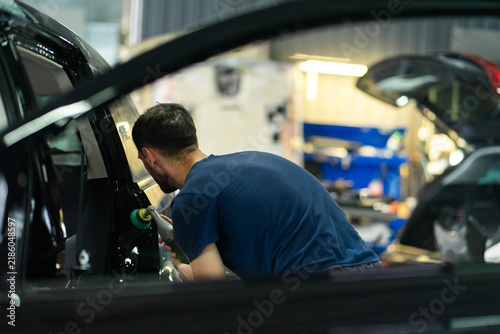 Canvas Print Mechanic uses tool to restore surface of door pillar of car