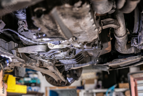Фотография Underside view of a vehicle showing greasy and oily residue around the lower engine oil pan, or sump, and nearby subframe components