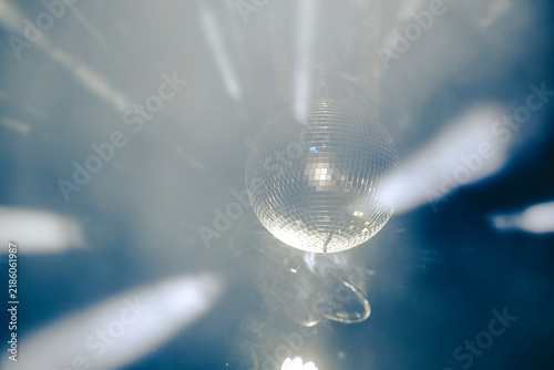 Фотография Sparkling disco ball reflecting bright lights in a dark nightclub or party venue with dynamic motion blur effect