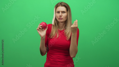 Canvas Print Woman holding a pomegranate and making a pinched fingers gesture while scrunching her face in studio; skepticism curiosity