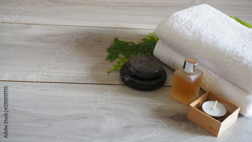 Photography Spa wellness arrangement featuring folded white towels, dark massage stones, an