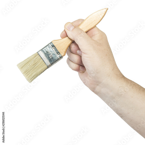 A hand holds a paintbrush with a wooden handle and metal ferrule.