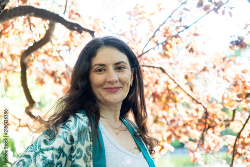 Happy adult female looking at camera outdoors, copy space for text