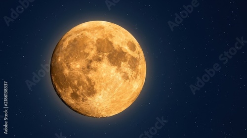 Full harvest moon shining in a dark blue starry night sky. Golden glowing moon astronomy background