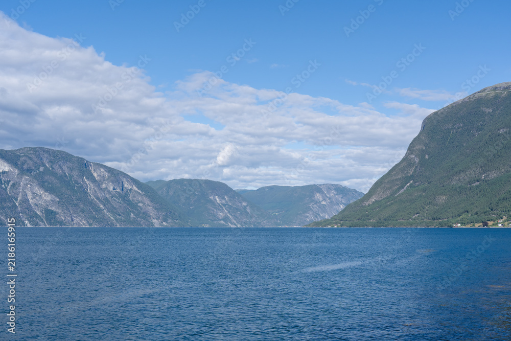 Obraz premium Scenic Norwegian fjord landscape with calm blue water and towering mountains