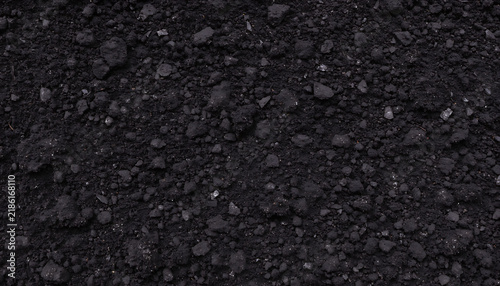 Closeup texture of dark fertile soil or compost for gardening and agriculture background