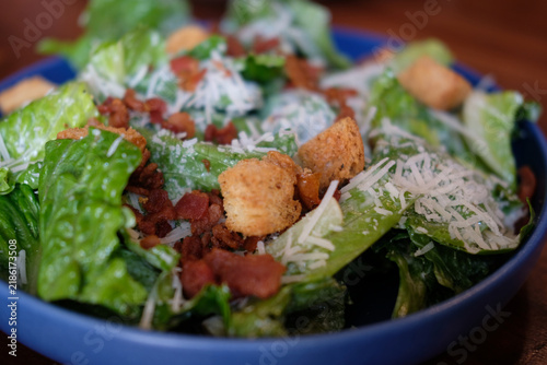 Foto Bowl of caesar salad with cheese and croutons. Close up