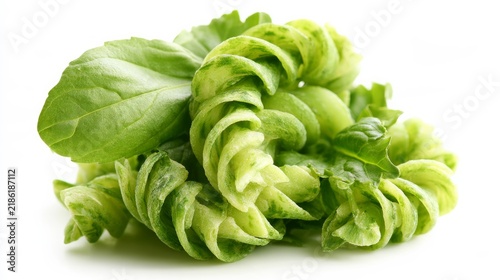 Spinach pasta spirals piled high, isolated on white.