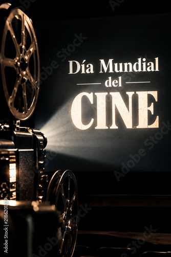 Fotografía publicitaria del Día Mundial del Cine con proyector cinematográfico retro proyectando un haz de luz sobre pantalla negra, concepto de cine clásico, película, espectáculo y cultura